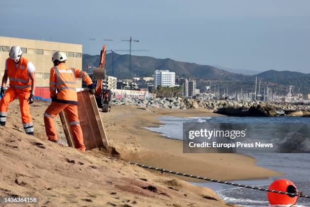 Two workers with the 2Africa submarine cable as it arrives at the Barcelona Cable Landing Station in Sant Adria de Besos, on 25 October, 2022 in Sant...