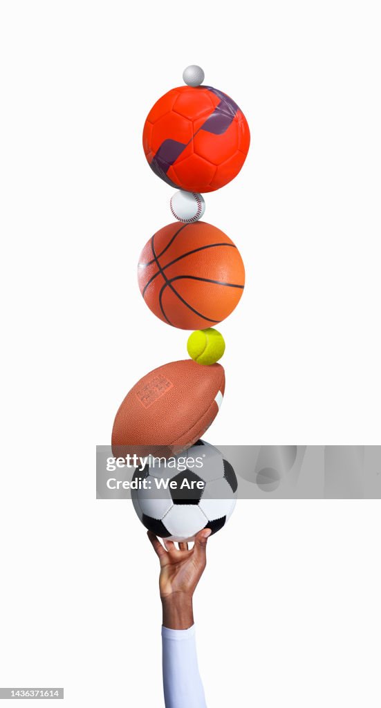 Hand with pile of sports balls