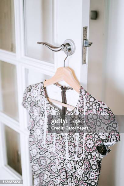 colorful blouse  hanging in hanger against white wall - hanging blouse stock pictures, royalty-free photos & images