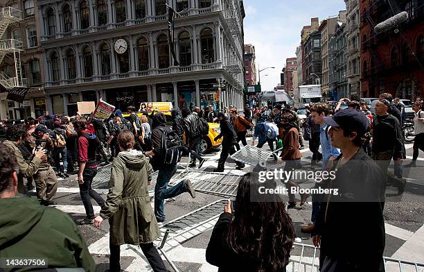 Demonstrators affiliated with the Occupy Wall Street movement drag police barricades down Broadway as they protest in New York, U.S., on Tuesday, May...