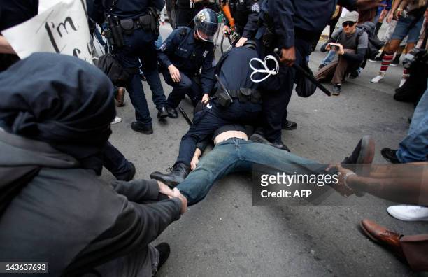 Occupy Oakland protesters try to pull a protester as he is getting detained by Oakland police officers near City Hall in downtown Oakland,...