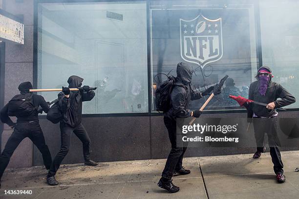 Protestors break the glass of a National Football League store during an Occupy Seattle May Day rally and anti-capitalist march in Seattle,...