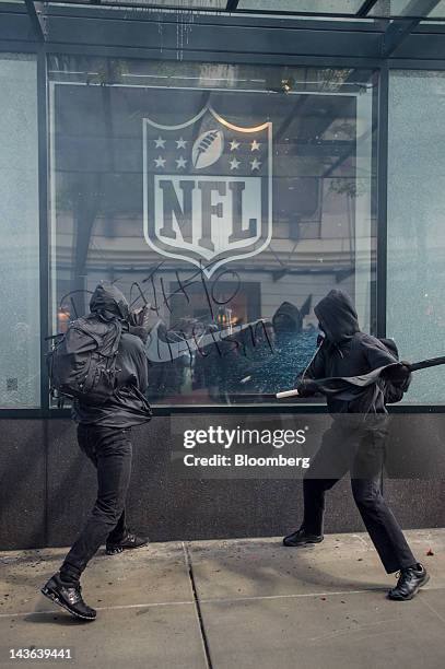 Protesters break the glass of a National Football League store during an Occupy Seattle May Day rally and anti-capitalist march in Seattle,...