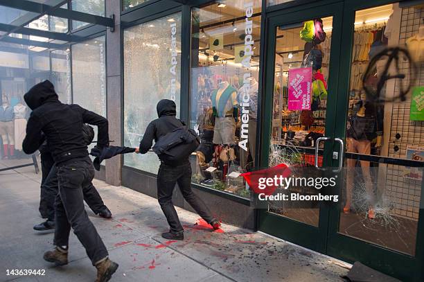 Protesters break the glass of a American Apparel Inc. Store during an Occupy Seattle May Day rally and anti-capitalist march in Seattle, Washington,...