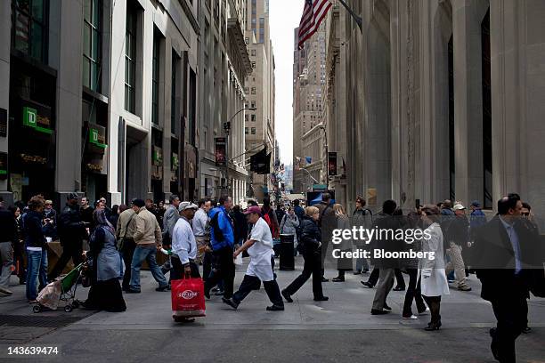 Pedestrians walk through Wall Street in New York, U.S., on Monday, April 30, 2012. Calls for a general strike with no work, no school, no banking and...