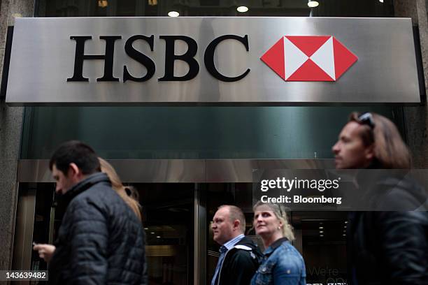 Pedestrians walk past an HSBC Holdings PLC branch in New York, U.S., on Monday, April 30, 2012. Calls for a general strike with no work, no school,...