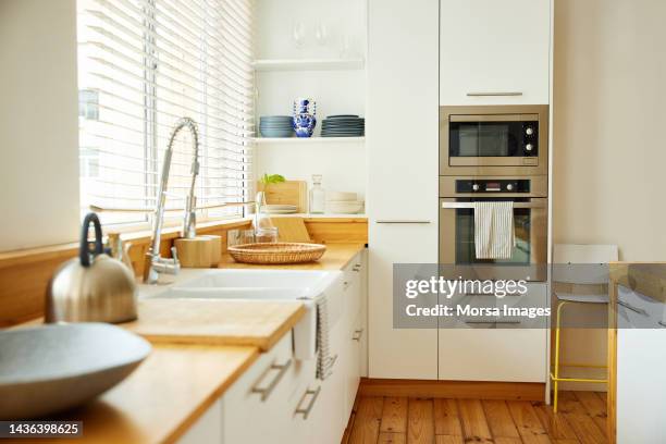 sink with faucet on kitchen counter by window - cooker fotografías e imágenes de stock