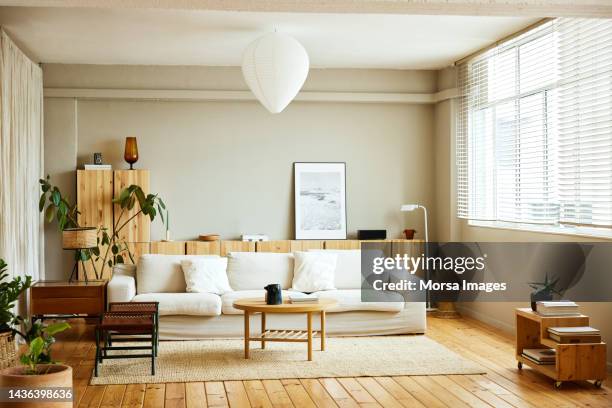 sofa with coffee table by window in living room - moderno foto e immagini stock