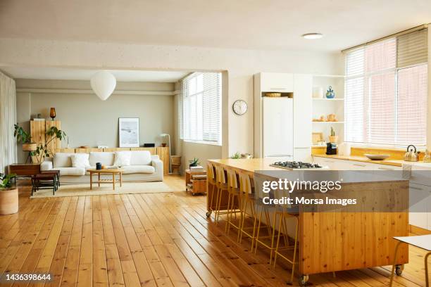 chairs arranged at kitchen island in apartment - case foto e immagini stock