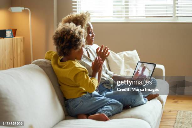 boy and mother waving at grandmother tablet pc - curly waves stock pictures, royalty-free photos & images