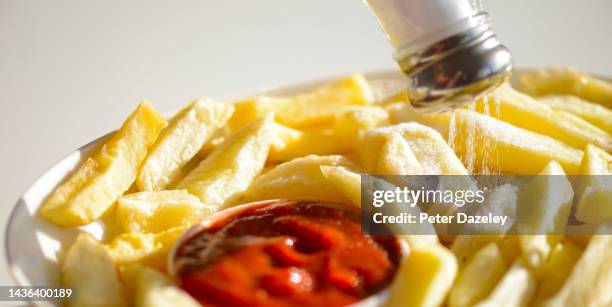 salt on french fries with tomato ketchup - sprinkling salt stock pictures, royalty-free photos & images