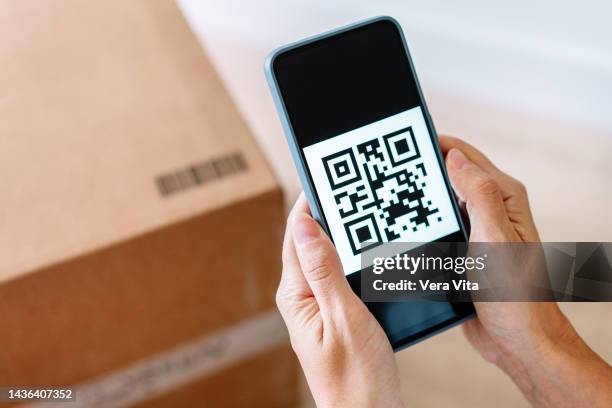 close up of qr code on screen phone display to locate a cardboard box - código-de-barras imagens e fotografias de stock