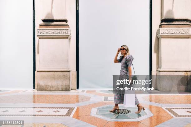 a beautiful businesswoman looking away after going shopping at the shopping mall - white shopping bag stock pictures, royalty-free photos & images