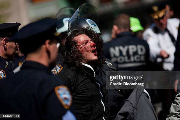 New York Police Department officers arrest a bloodied demonstrator affiliated with the Occupy Wall Street movement in New York, U.S., on Tuesday, May...