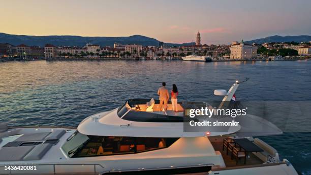 couple standing on yacht - luxe jacht stockfoto's en -beelden