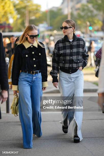 Guest wears black sunglasses, a black velvet with pale yellow sheep collar jacket from Chanel, a black shiny leather belt, blue denim wide legs...