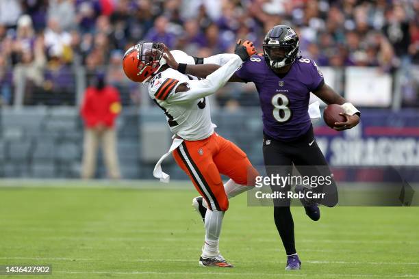 Quarterback Lamar Jackson of the Baltimore Ravens stiff arms linebacker Deion Jones of the Cleveland Browns while running with the ball at M&T Bank...