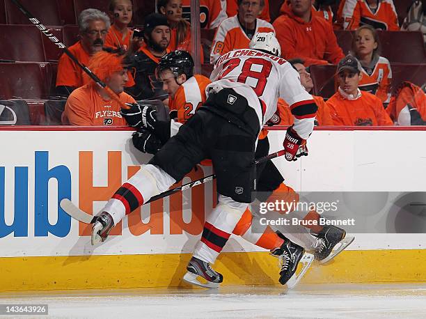 Anton Volchenkov of the New Jersey Devils hits Matt Read of the Philadelphia Flyers into the boards in Game Two of the Eastern Conference Semifinals...