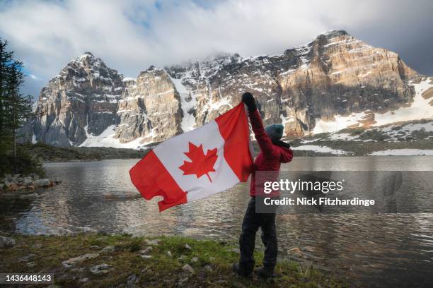 flying the canadian flag on canada day at eiffel lake, valley of the ten peaks, banff national park, alberta, canada - kanadas flagga bildbanksfoton och bilder