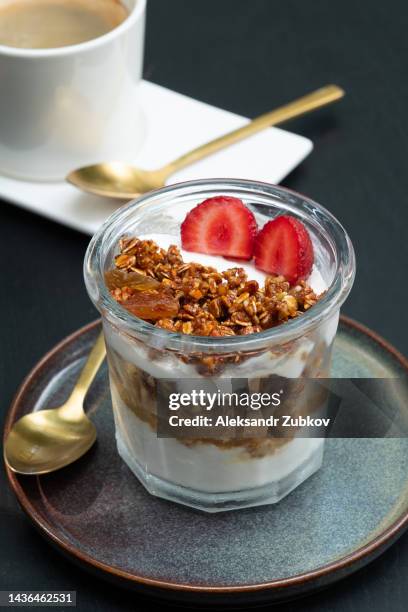 a glass of fruit and yogurt parfait. vegetarian and vegan dessert with honey muesli or granola. diet vanilla ice cream with strawberries in a glass. an exquisite dish. serving food and drinks in a cafe, at home or in a restaurant. sustainable development. - fruit parfait stock pictures, royalty-free photos & images