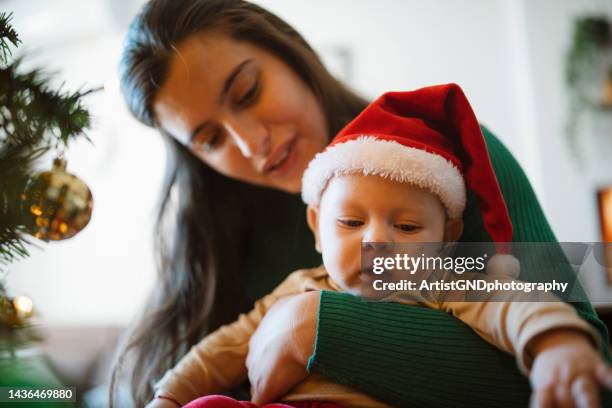 cute baby boy and his mom next to christmas tree. - winter baby stockfoto's en -beelden