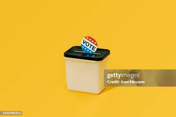 a vote badge in a ballot box - presidentskandidaat stockfoto's en -beelden