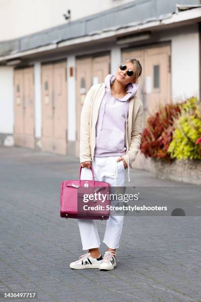 Influencer Gitta Banko wearing a beige sweat blazer by Gitta Banko, a lavender hoodie by Nili Lotan, white pants by Nili Lotan, a berry colored...