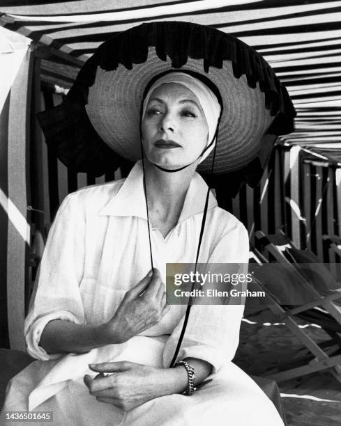 Portrait of Russian-Ukrainian fashion designer Valentina in a sunhat in a tent at Lido Beach, Venice, Italy, 1959.