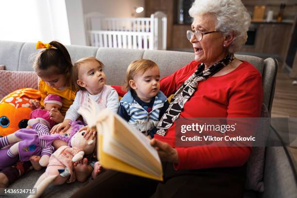 happy grandmother with her three little granddaughters - three children stock pictures, royalty-free photos & images