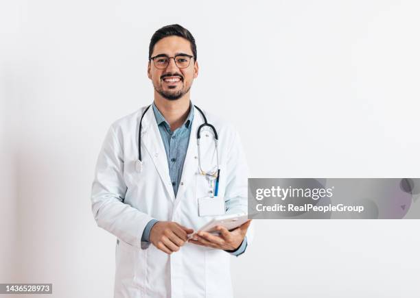 doctor standing and smiling on white background - cardiologist portrait stock pictures, royalty-free photos & images