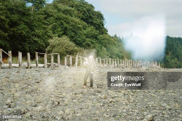 abstract shot of a mother holding her daughter while walking on a rocky beach - whidbey island bildbanksfoton och bilder