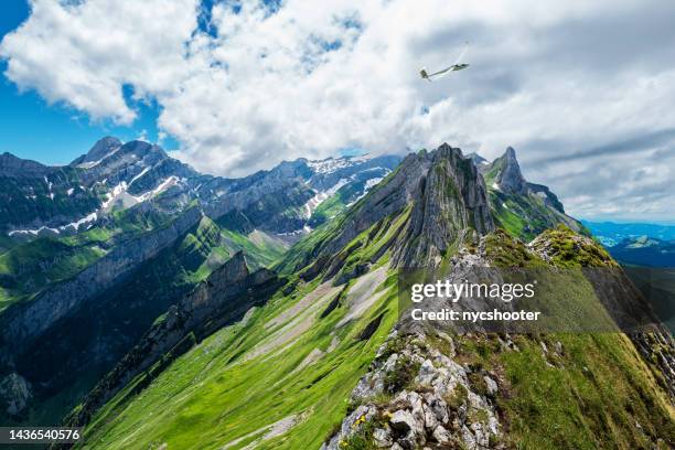 glider over altenalp turm in alpstein area of switzerland - zweefvliegtuig stockfoto's en -beelden