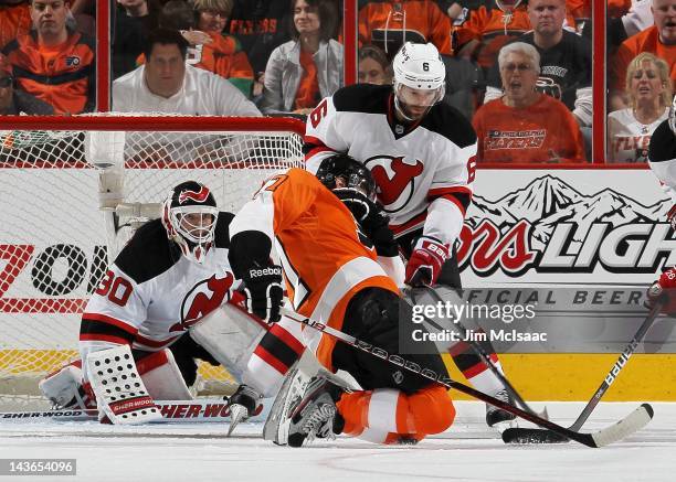 Martin Brodeur and Andy Greene of the New Jersey Devils in action against Eric Wellwood of the Philadelphia Flyers in Game One of the Eastern...