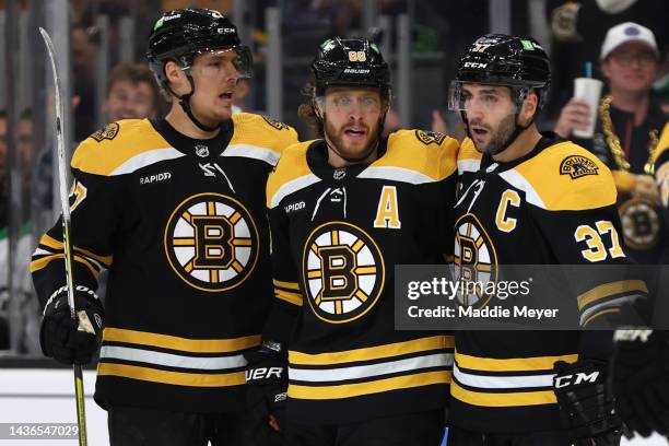 David Pastrnak of the Boston Bruins celebrates with Hampus Lindholm and Patrice Bergeron after scoring a goal against the Dallas Stars during the...