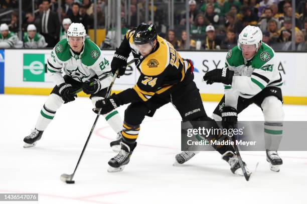 Jake DeBrusk of the Boston Bruins skates against Ryan Suter and Roope Hintz of the Dallas Stars during the first period at TD Garden on October 25,...