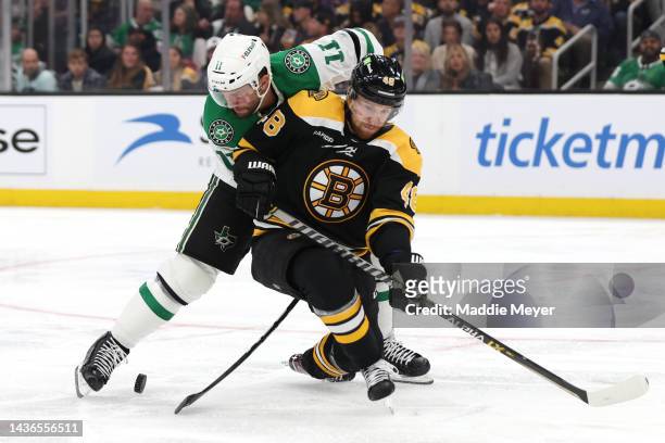 Luke Glendening of the Dallas Stars and Matt Grzelcyk of the Boston Bruins battle for control of the puck during the second period at TD Garden on...