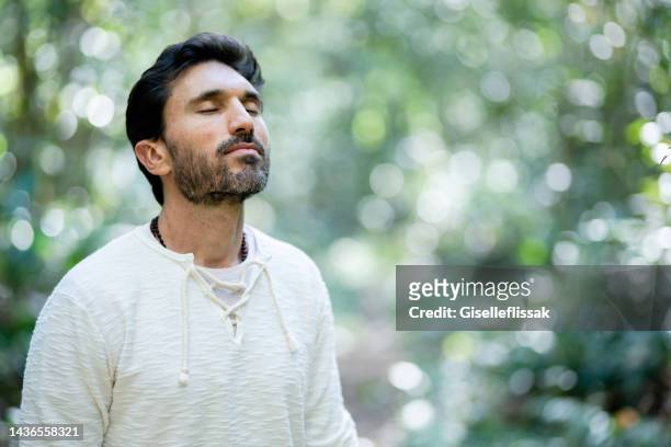 man taking a breath of fresh air while walking in a forest - fresh air breathing stockfoto's en -beelden