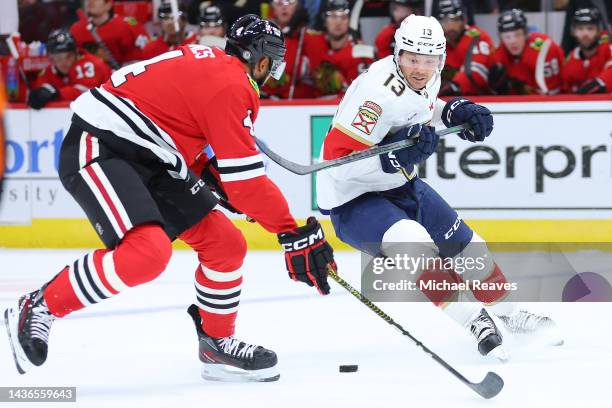 Seth Jones of the Chicago Blackhawks and Sam Reinhart of the Florida Panthers battle for control of the puck during the first period at United Center...