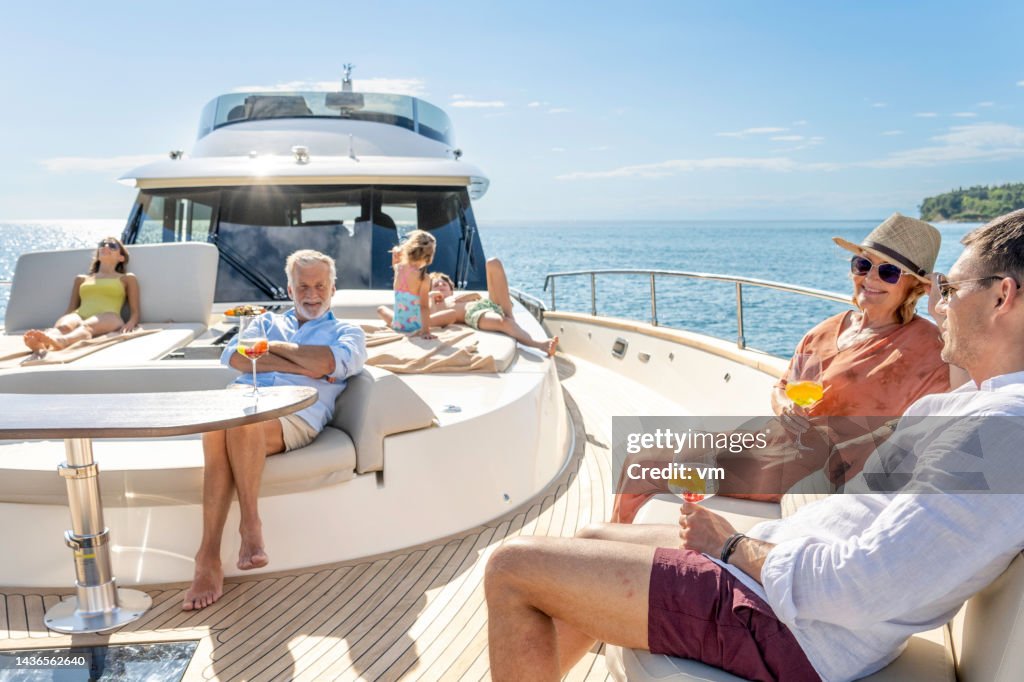 Mehrgenerationenfamilie genießt Kreuzfahrt auf Yacht an sonnigen Tagen