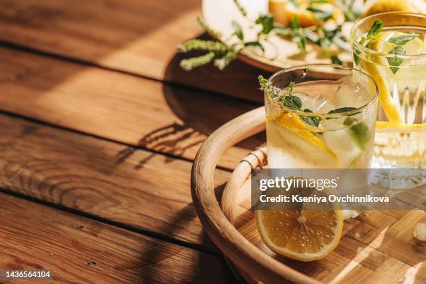 cool freshly made lemonade and fruits on grey wooden table. space for text - infused water stockfoto's en -beelden