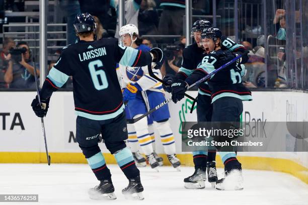 Adam Larsson, Daniel Sprong and Morgan Geekie of the Seattle Kraken celebrate Geekie's goal against the Buffalo Sabres during the first period at...