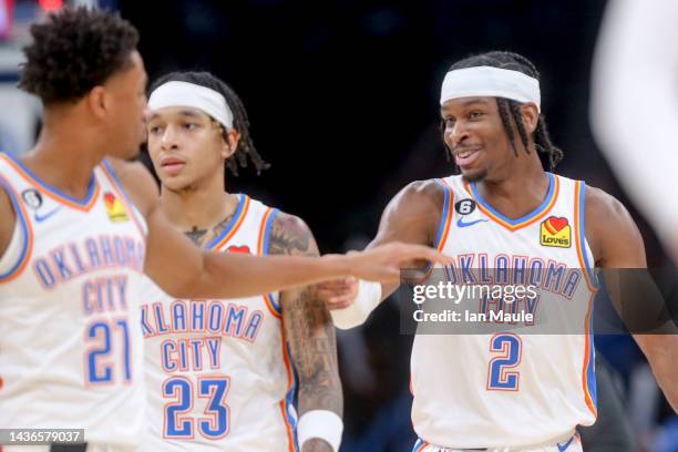 Shai Gilgeous-Alexander, Aaron Wiggins and Tre Mann of the Oklahoma City Thunder celebrate during a timeout in the third quarter against the Los...