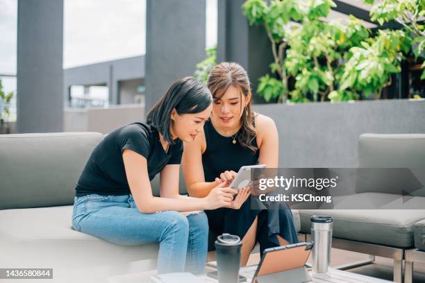 two asian women checking crypto currency - token stock pictures, royalty-free photos & images