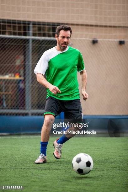 amateur-sportfan beim fußballspielen auf dem feld - amateur stock-fotos und bilder
