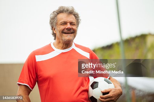 Joueur De Football Masculin Mature Marchant Tout En Tenant Le Ballon Photo  - Getty Images