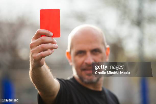 amateur football match referee shows red card to player before sending him off - foul 個��照片及圖片檔