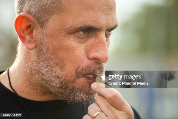 close-up shot of football game referee blowing whistle at start of game - blame game stock pictures, royalty-free photos & images