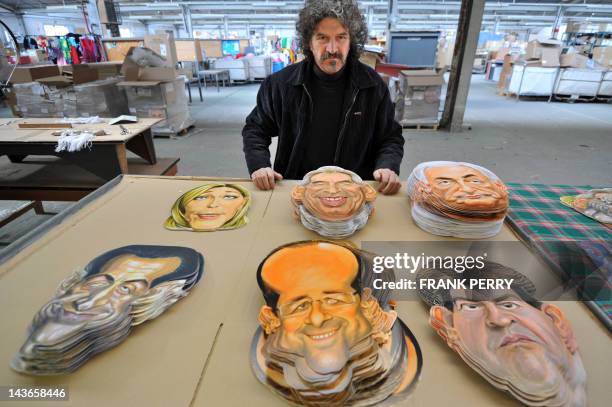 Michel Foucault drawner and sculptor at the Cesar mask maker company poses in front of 2012 French presidential election candidates masks he created,...