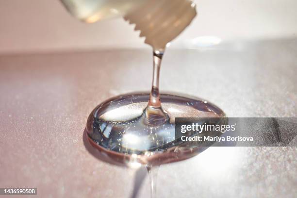 a drop of shampoo or gel on a pink background. - facial cleanser stockfoto's en -beelden