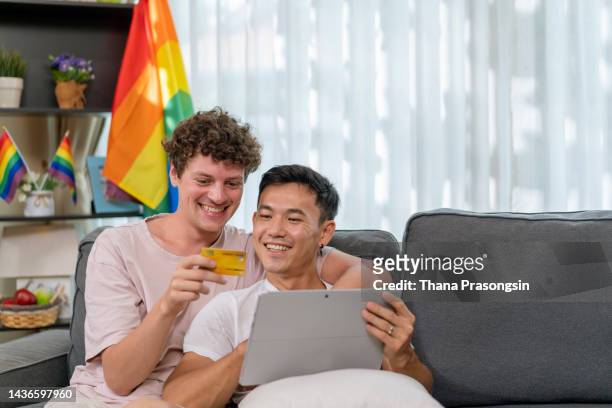 gay men shopping online through computer at home - native korean stock-fotos und bilder